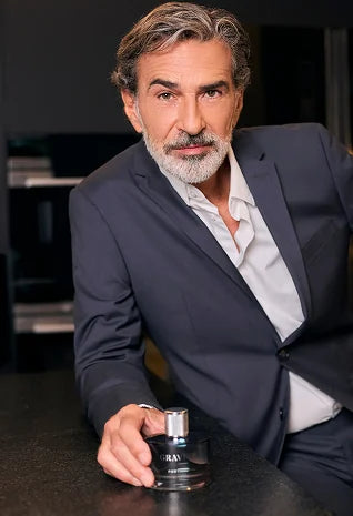 Elegant man holding Gravité men’s fragrance