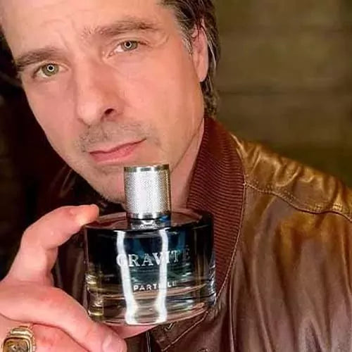 Andy holding a Gravité fragrance bottle